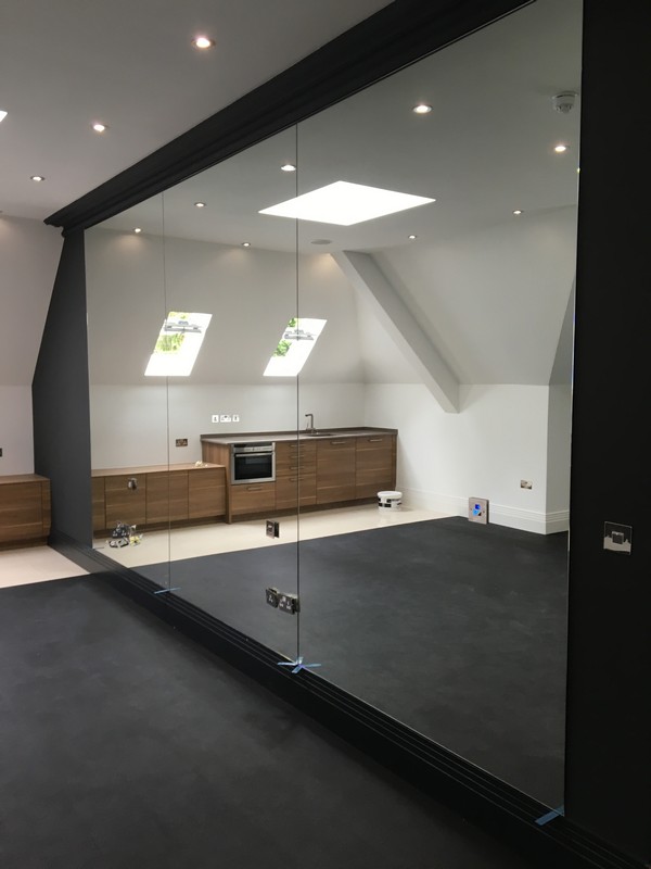 Frameless glass partition in loft conversion by Walthamstow glaziers